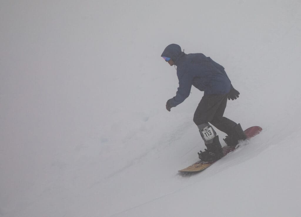 Jeffery Fox weaves through the fog as he slides down the snow.