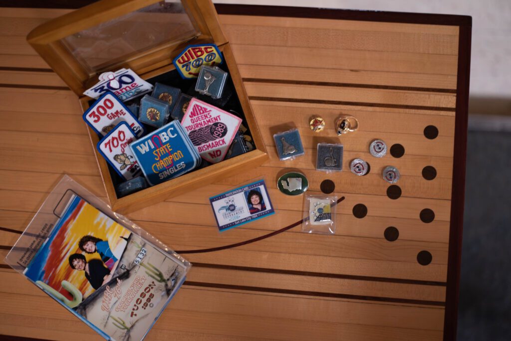 Vintage bowling patches and pins lay on a table made from an old bowling lane.