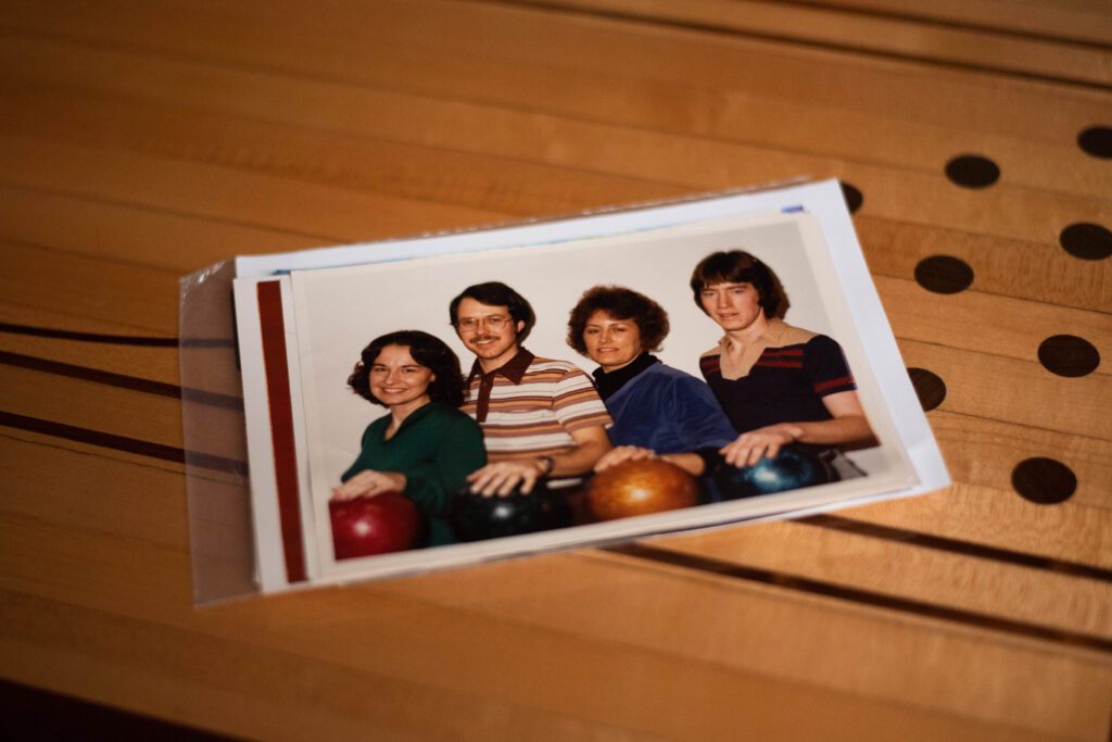 An old photograph of four bowlers lays on a table made out of a bowling lane.