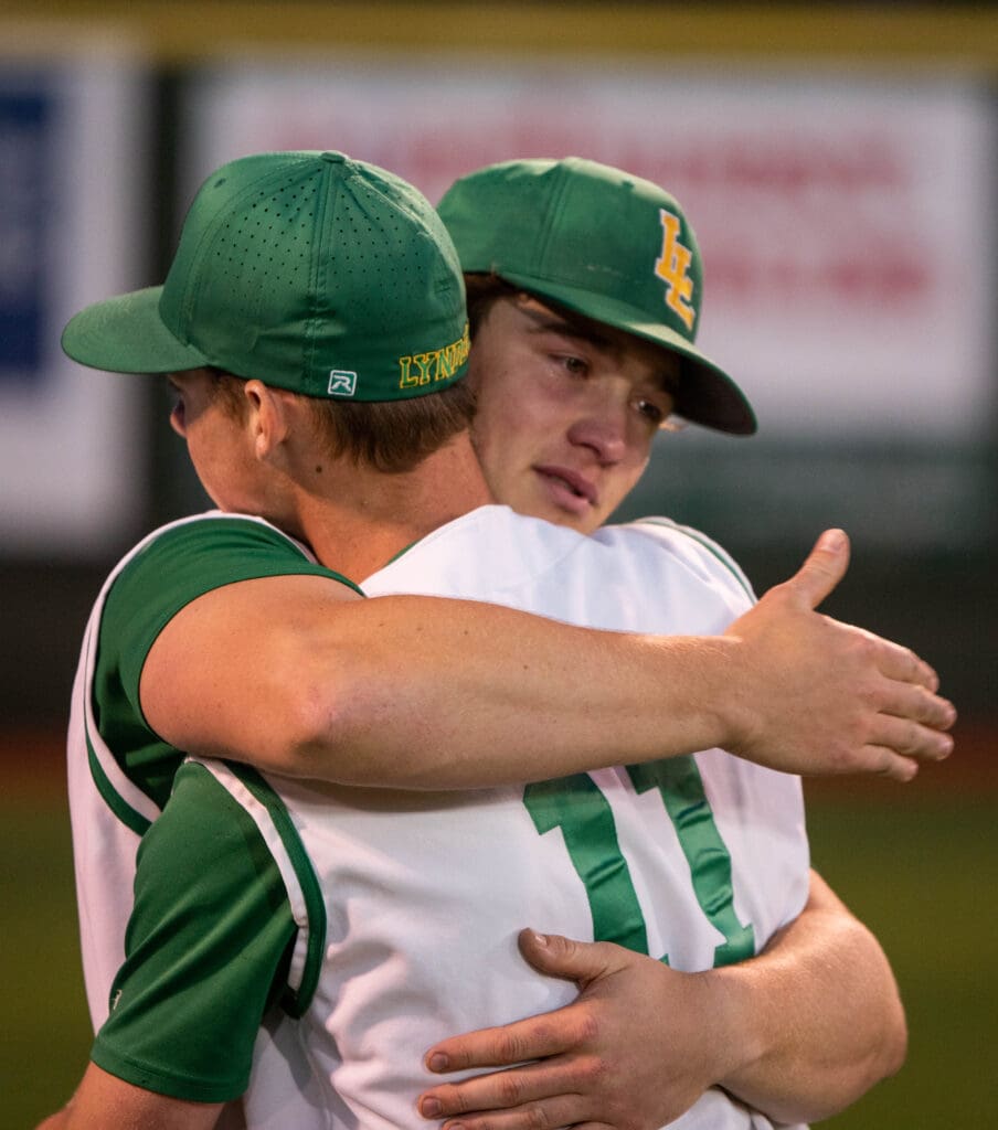 Lynden senior outfielder Campbell Nolte hugs junior Austin Tolsma by wrapping their arms around each other.