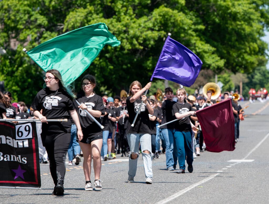 Color guard members of the All-Bellingham Middle School Band spin flags during their performance.