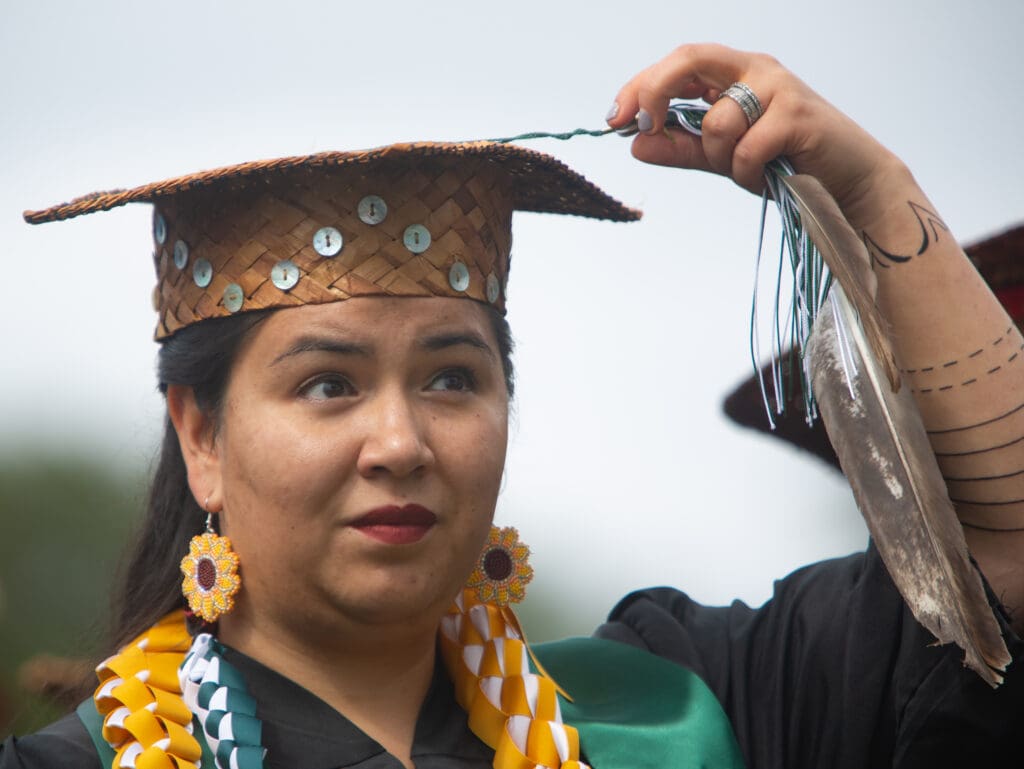 Student speaker and member of the Makah Tribe and Lummi Nation, Sandra James, turns her tassle.