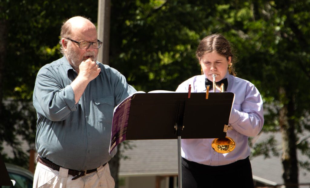 Annelisa Crosetti, right, plays "Somewhere Over the Rainbow" on her trumpet as Don Reinke stands beside her as they both read the music sheet.