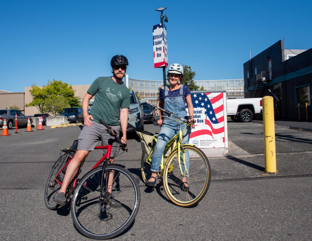 Geralde Jones, left, and Miranda Leon Jones smile on top of their bicycles after dropping off their ballots.