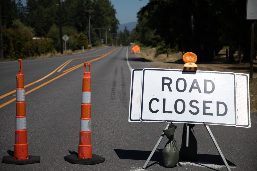 A road closed sign blocks entry for cars.