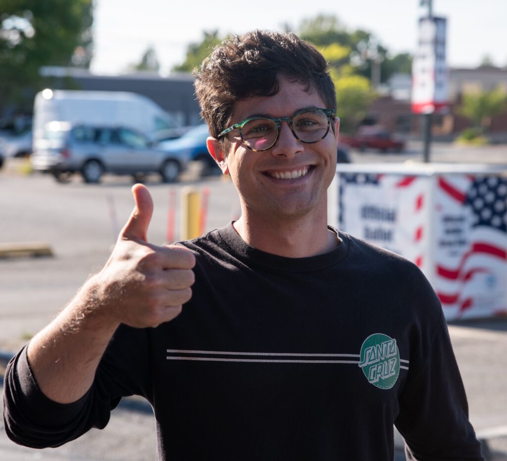 James Bishop gives a thumbs up after casting his vote with a wide smile.