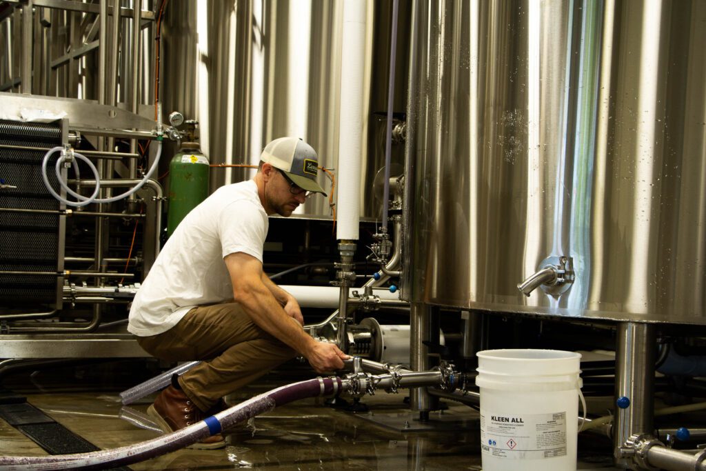 Sam Milne tinkering with one of his metal beer vats.