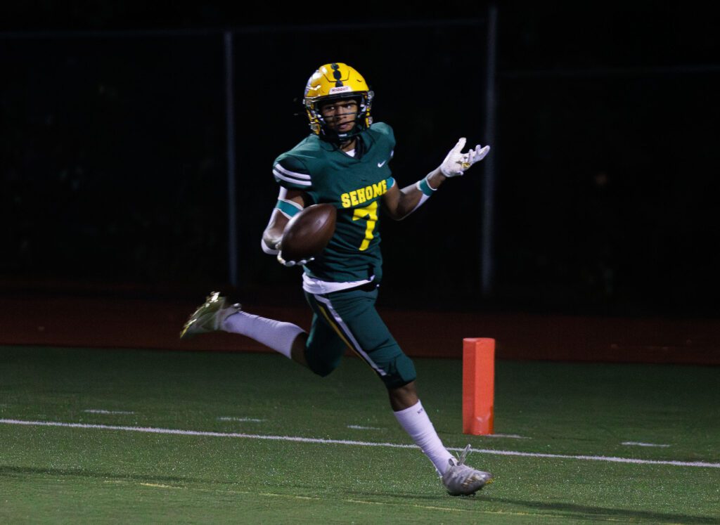 Sehome's Andre Watson reacts as he gestures with both hands as he slows down at the endzone.