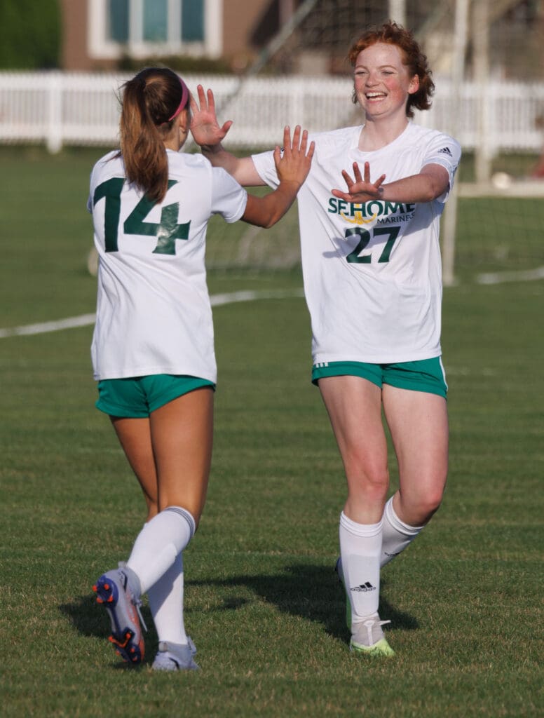 Sehome’s Ella Perry high-fives a teammate as they walk away from the goal.