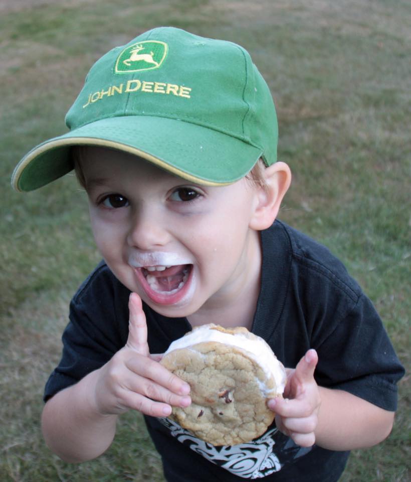 Conner Curry, a poster child for Moo-Wiches, smiles happily with ice cream on his mouth.