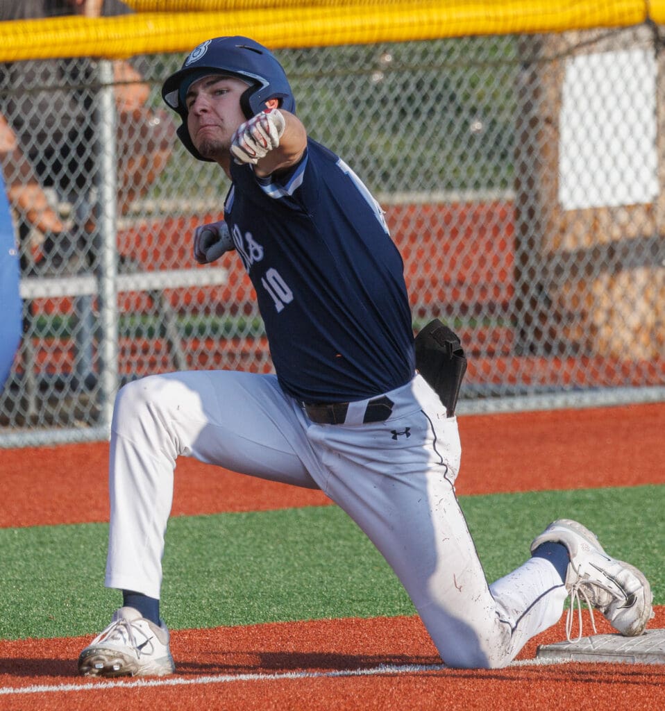 Bellingham Bells' Max Hartman pumps his arms in celebration with one knee on the ground.