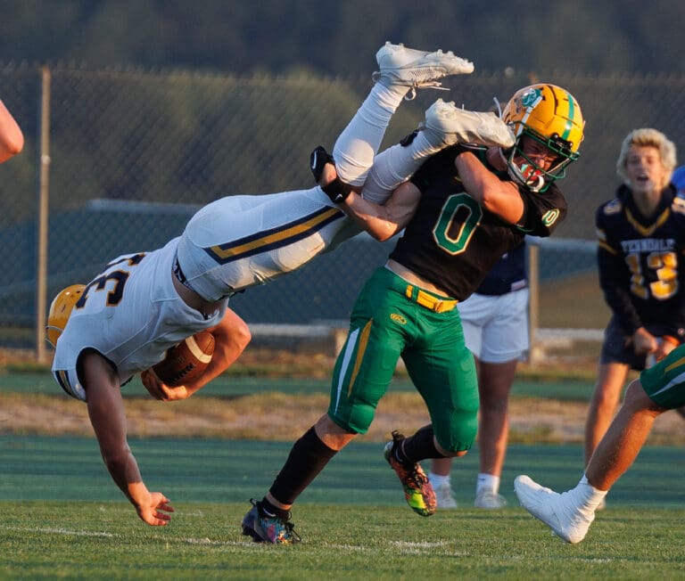 Cooper Moore tries to stop Talan Bungard diving to score a touchdown as he holds onto his legs.