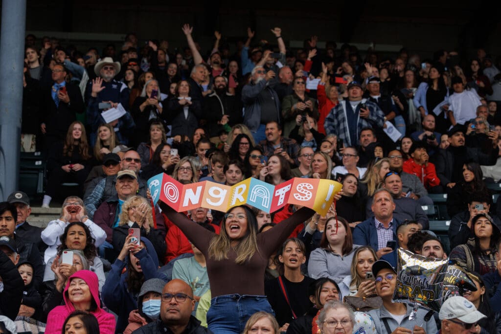 Friends and families cheer as soon-to-be graduates take their seats.