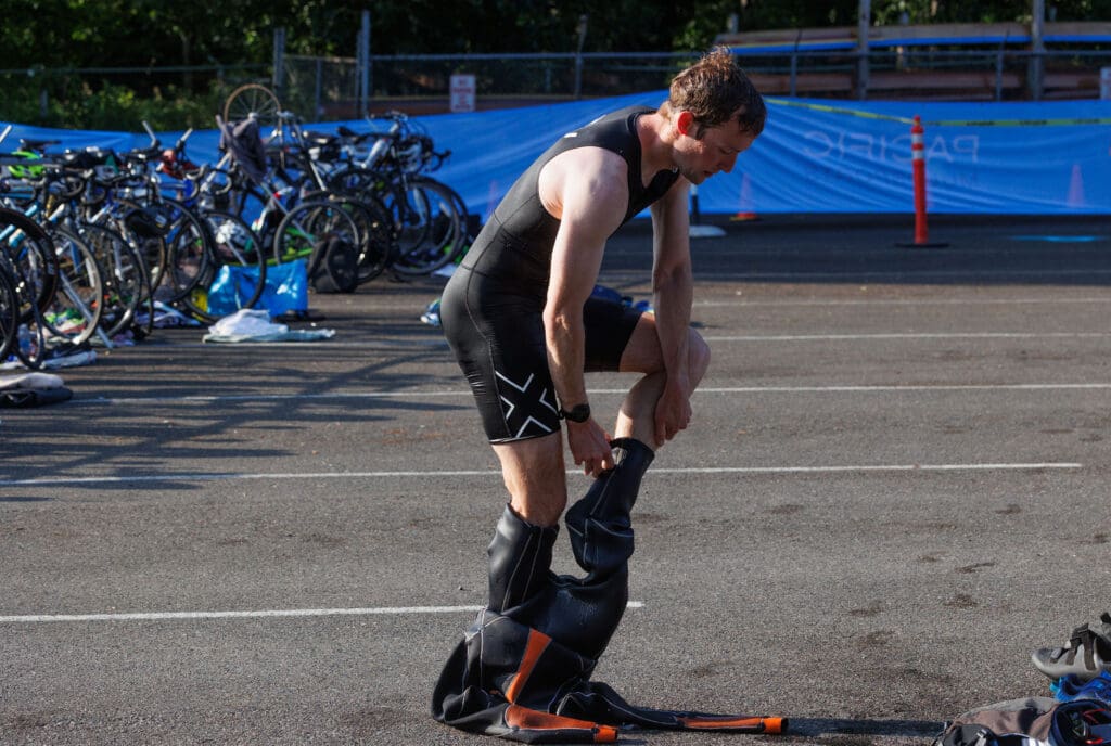 Racer Gerry Thiers struggles to get out of his wetsuit in the transition area.