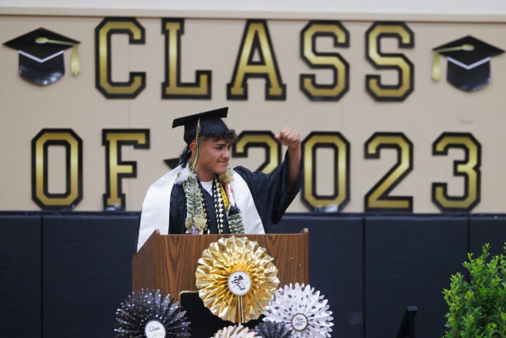 Class speaker Roberto Guzman pumps his fist after finishing his speech during the graduation ceremony.