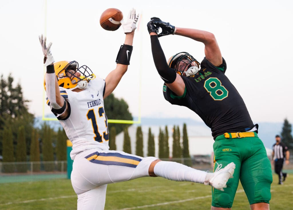 Ferndale’s Bishop Ootsey and Lynden’s Isaiah Oudman both leap into the air to catch the football.