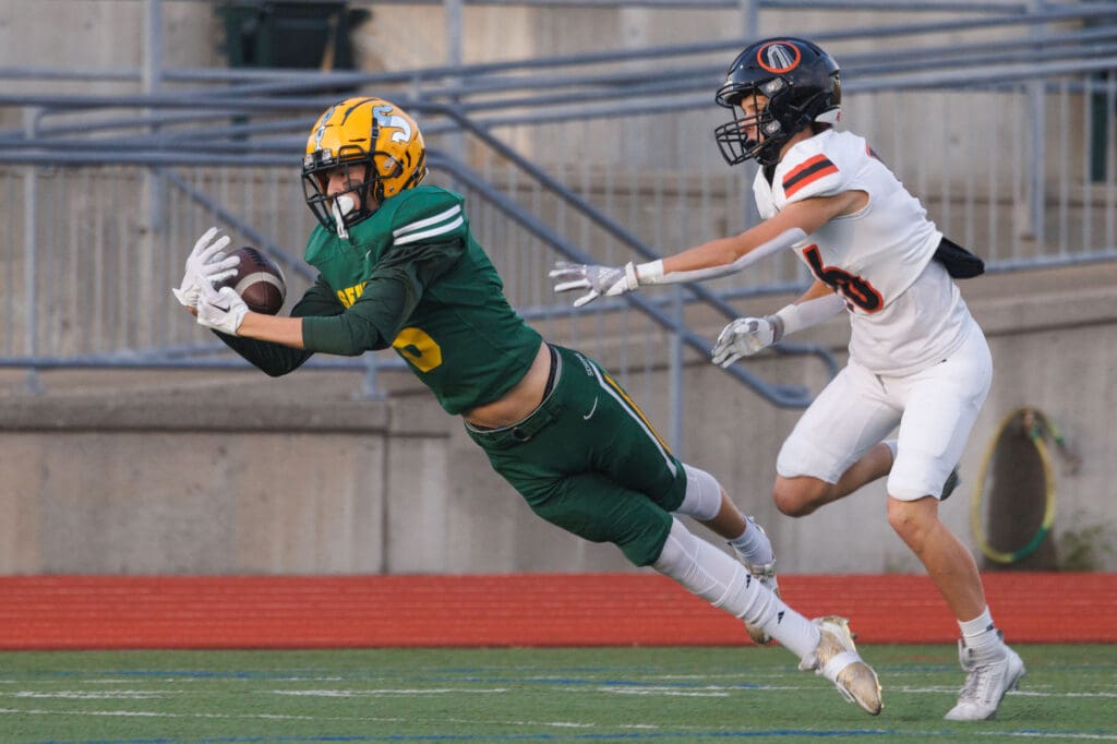 Sehome's Theo Quiggle dives to make a catch as the opposing team's player reaches to grab him.