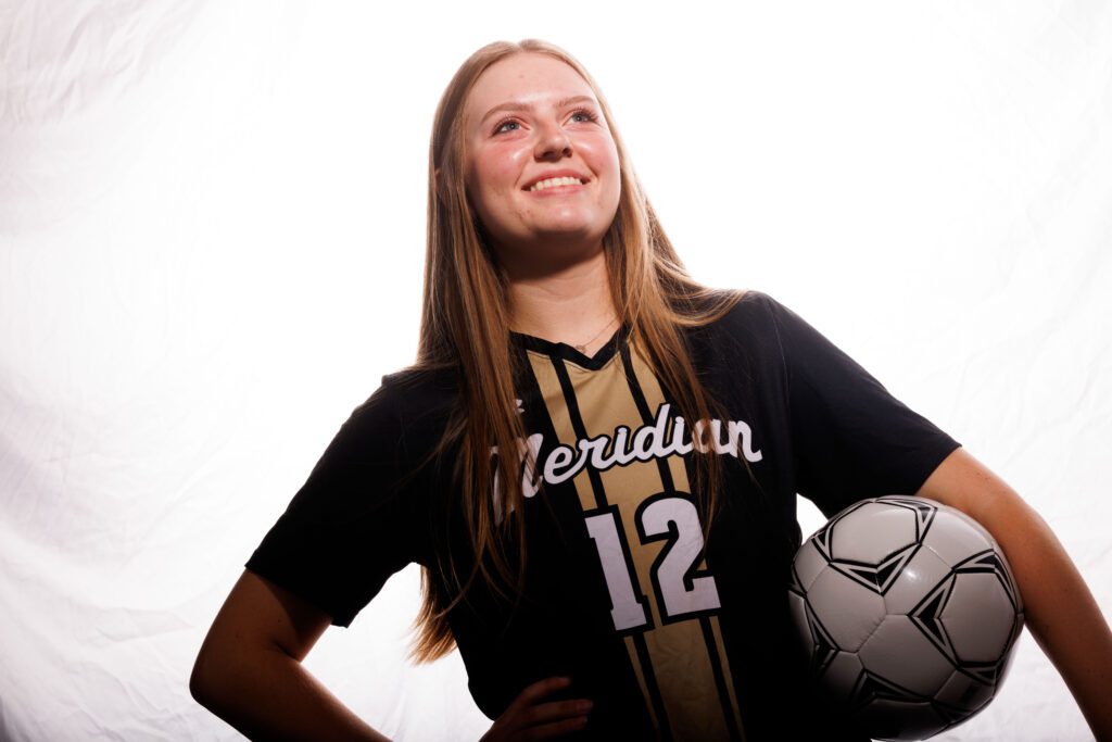 Meridian girls soccer center midfielder Allie Richter looks on with the ball.