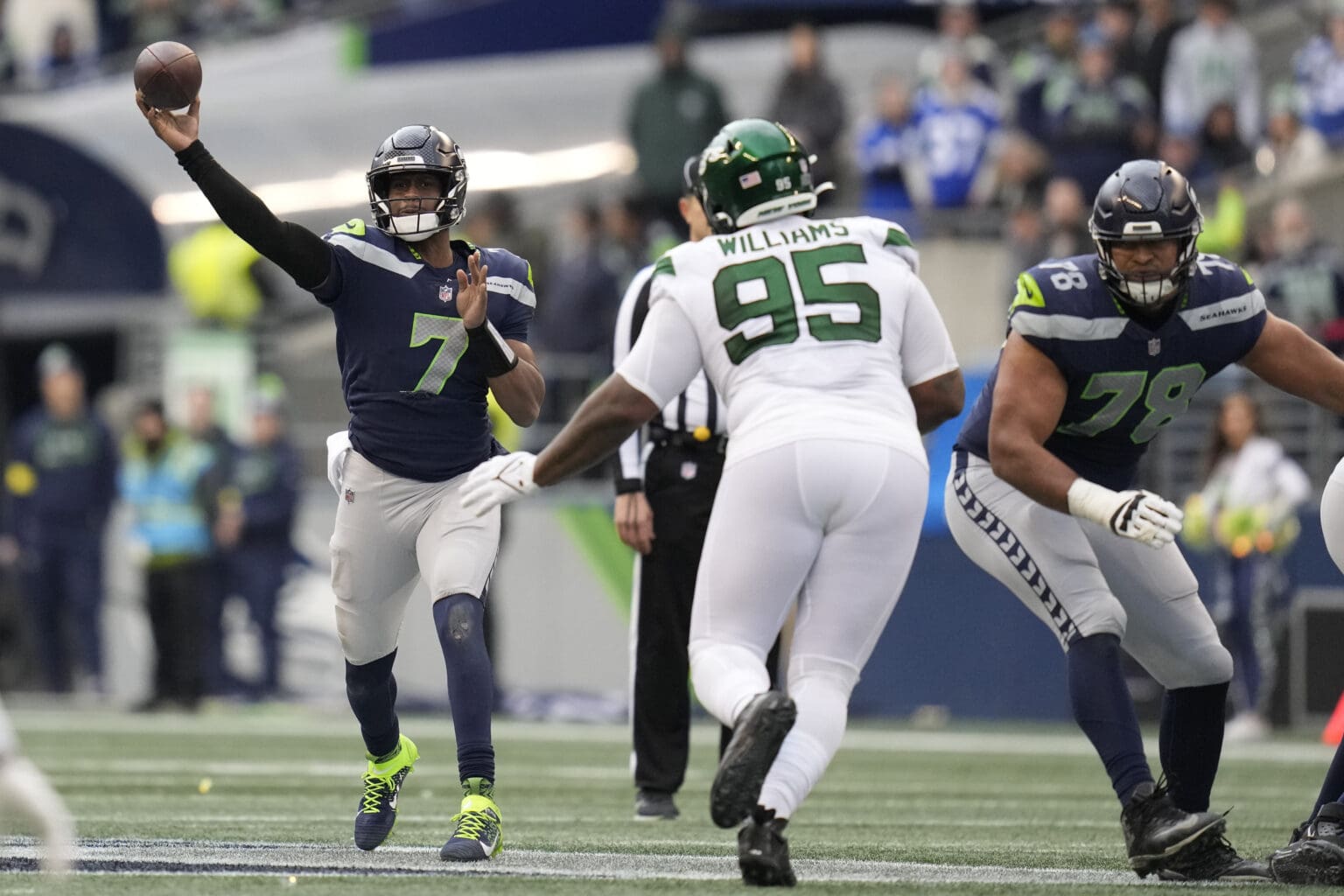 Seattle Seahawks quarterback Geno Smith (7) looks to throw a pass as defenders rush over to block the shot.