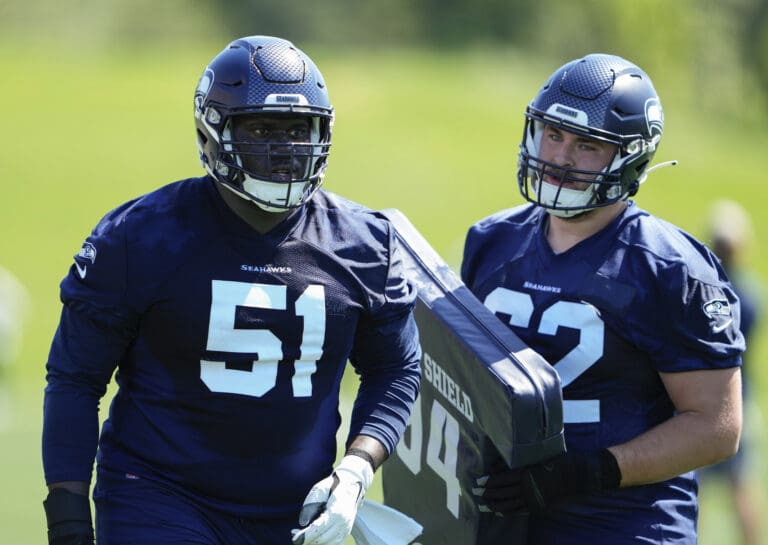 Seattle Seahawks center Olu Oluwatimi (51) and center Alex Mollette (62) regroup after a drill as one of them holds onto a cushioned barrier used for drill practice.