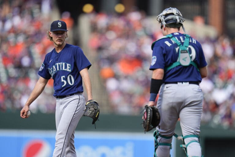 Seattle Mariners starting pitcher Bryce Miller (50) and catcher Cal Raleigh (29) gather near the mound between batters.