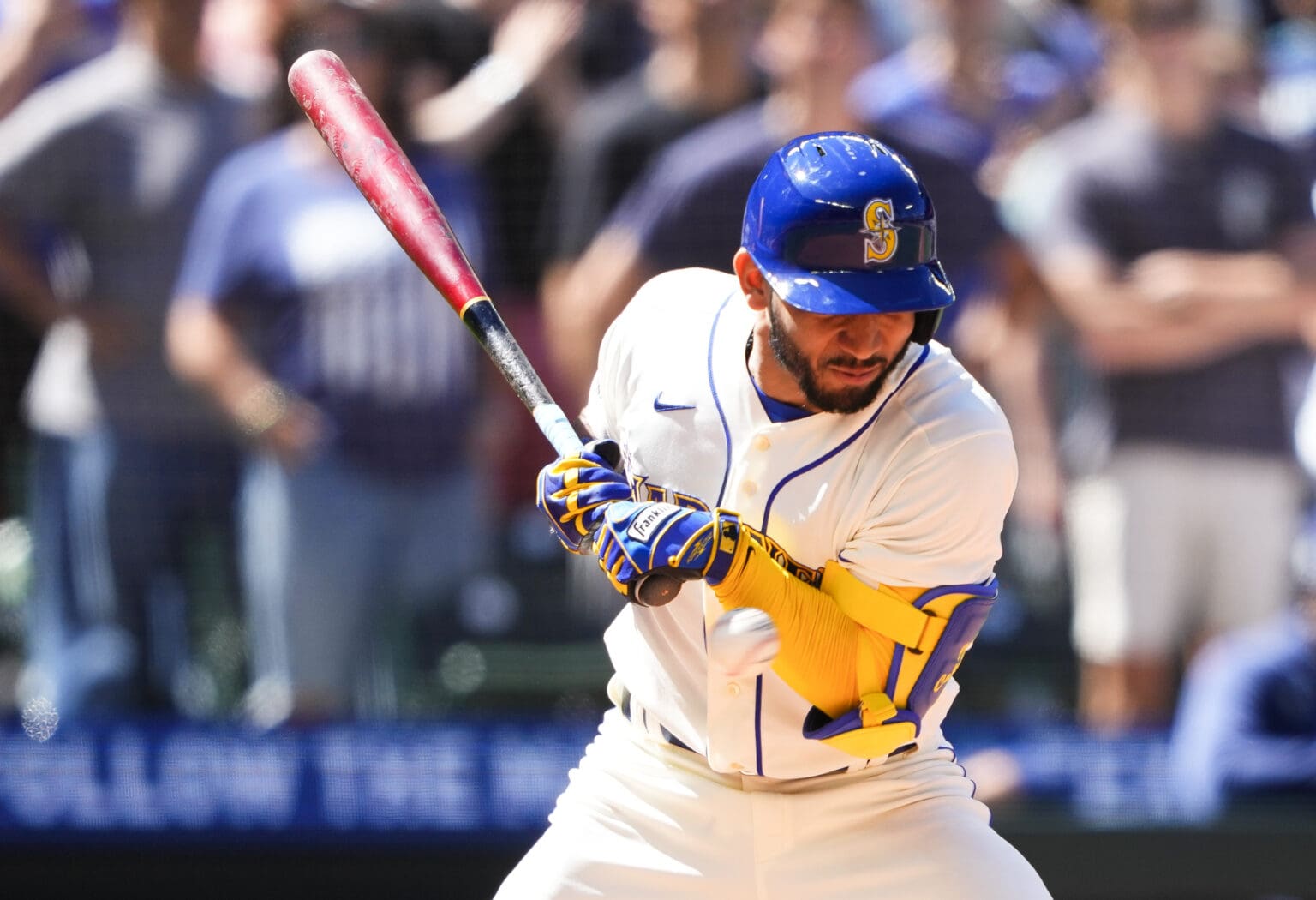 Seattle Mariners' Jose Caballero pulls his bat up to his side as a crowd watches from the bleachers.