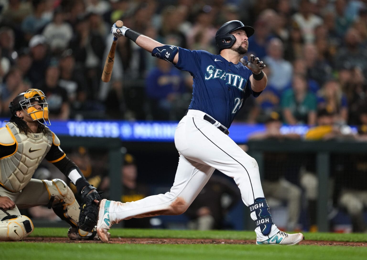 Seattle Mariners' Cal Raleigh looks up in reaction to the ball he just bat.