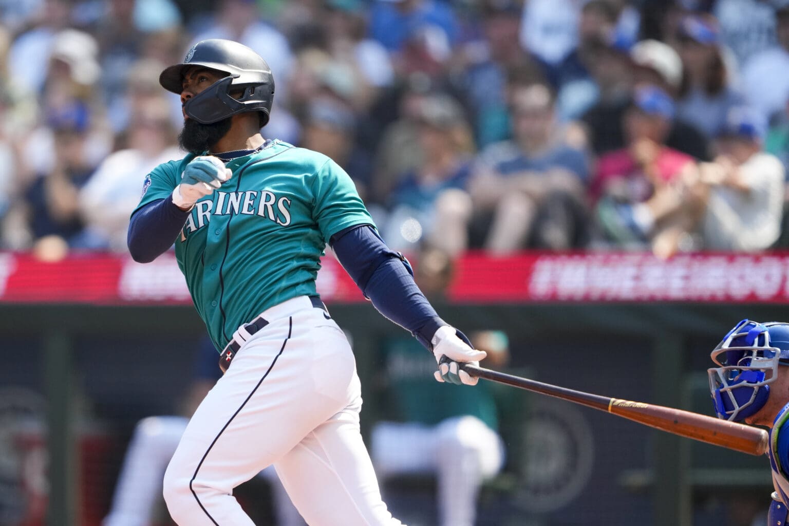 Seattle Mariners' Teoscar Hernandez follows through on a hit as his bat ends up behind him.