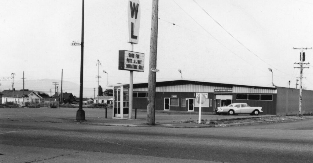 A black and white photograph shows the exterior of an old bowling alley.