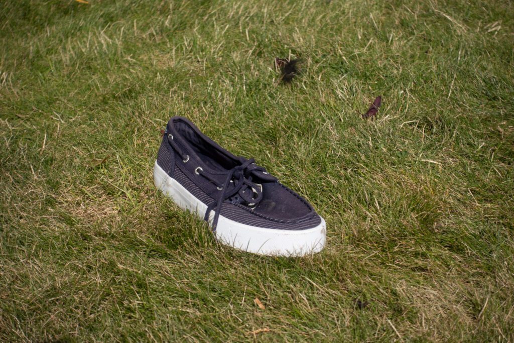 A black and white shoe sits on the grass.