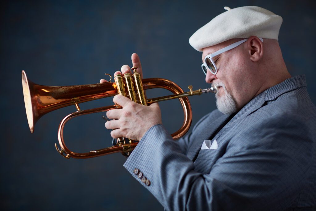 Horn hotshot Dmitri Matheny plays the trumpet while dressed sophisticatedly.