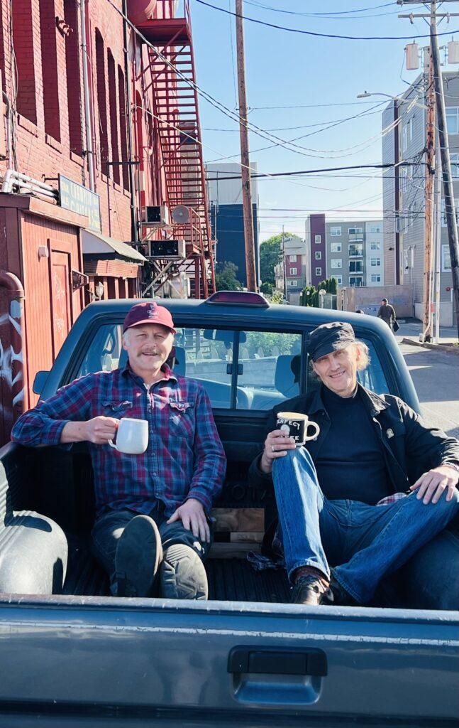 The Dusty Mugs sitting in the back of a pickup truck with mugs in their hands.