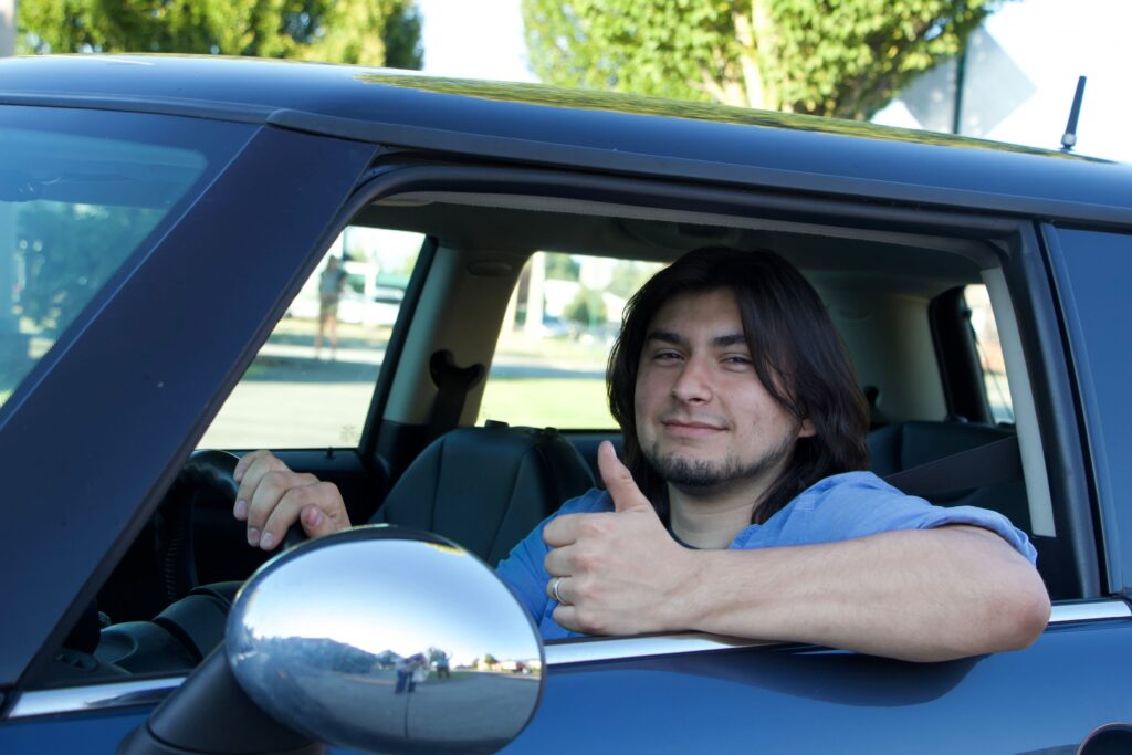 Nathan Wilson, 23, gives a thumbs up from the window of his car.