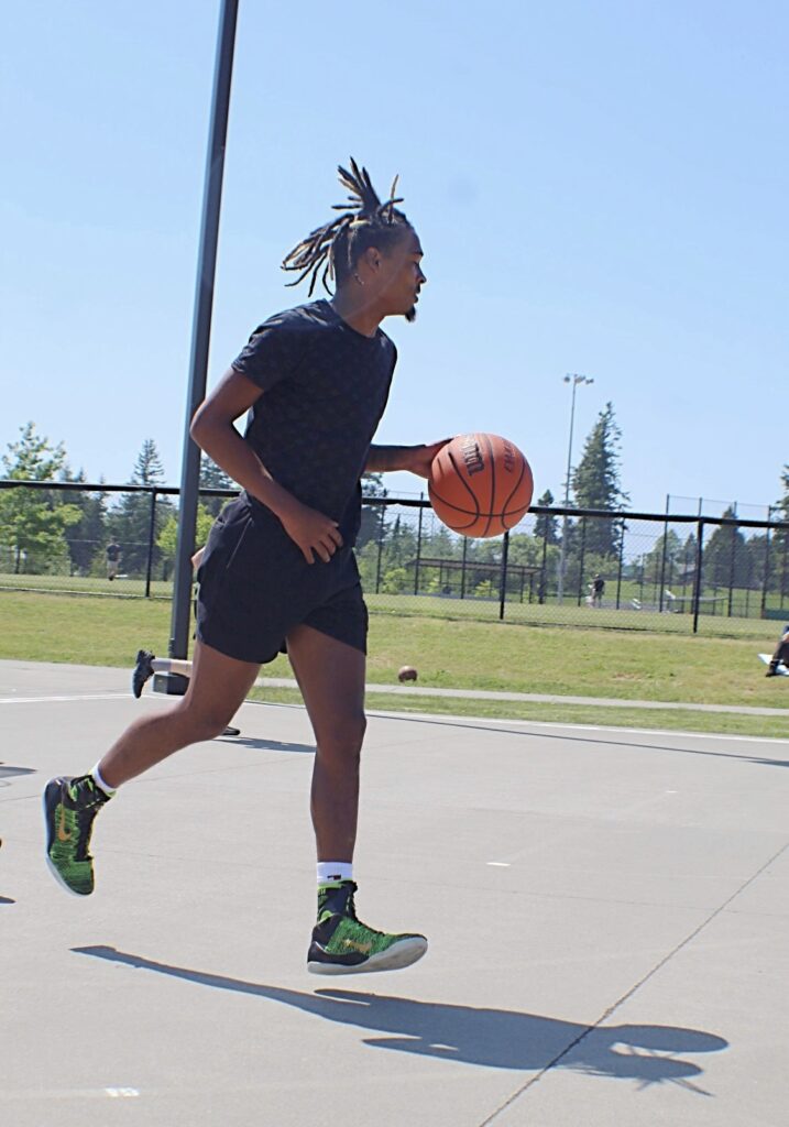 Maleek James dribbles the ball across the basketball court.