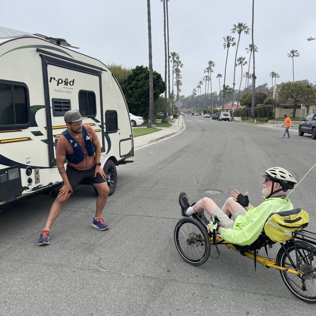 Marcus Nuckolls, left, talks with recumbent biker Dan as he stretches his legs.