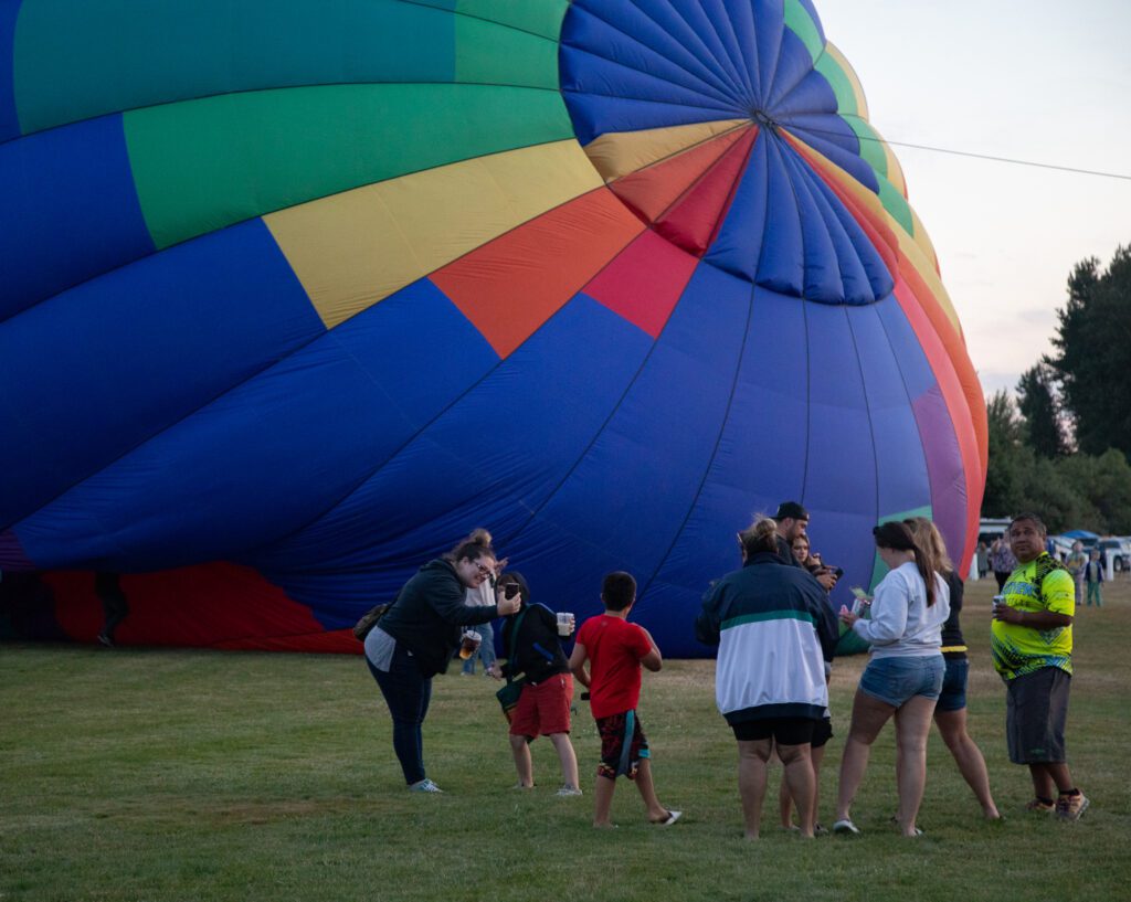 People take pictures of a balloon mid-setup.