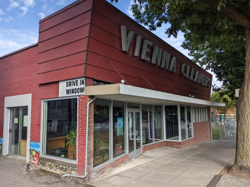 Vienna Cleaners' red storefront has a drive in window.