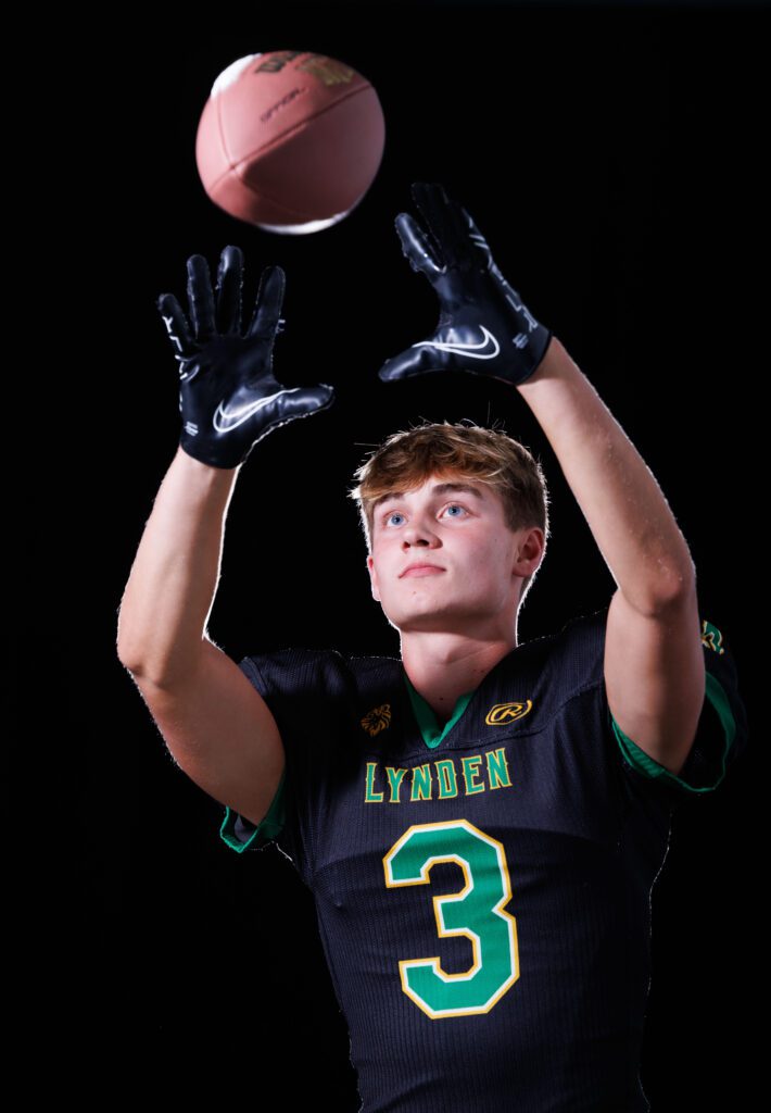 Lynden football wide receiver and safety Weston VanDalen catches a ball with both hands.