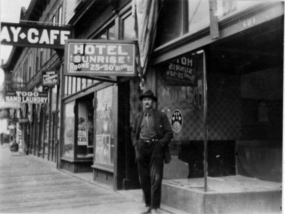 A vintage photo of one of the local IWW union branches with a man at the front has his hands in his pocket.