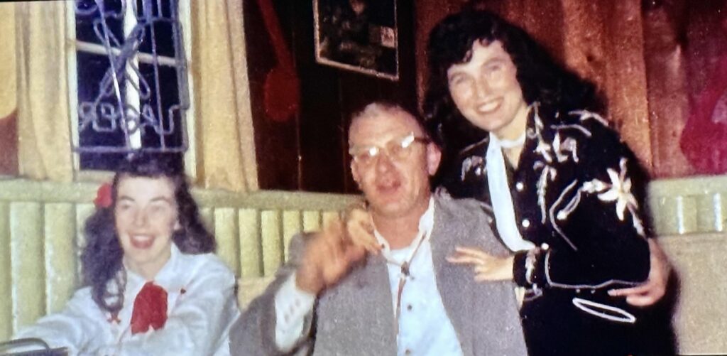 An old photo of Darlene Little poses with a booking agent and the steel guitar player Alvin "Duke" Saulsbury and Legend Loretta Lynn at Bill's Tavern.