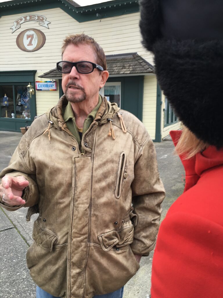 Legendary author Tom Robbins talks about art in front of the Pier 7 building.