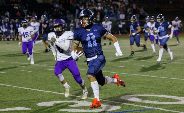 Lynden Christian's Dawson Bouma scores a touchdown followed closely by other players.