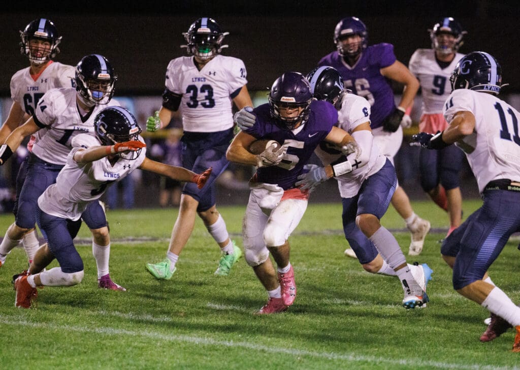 A Nooksack Valley ball carrier rushes upfield as many players crowd around him to take control of the ball.