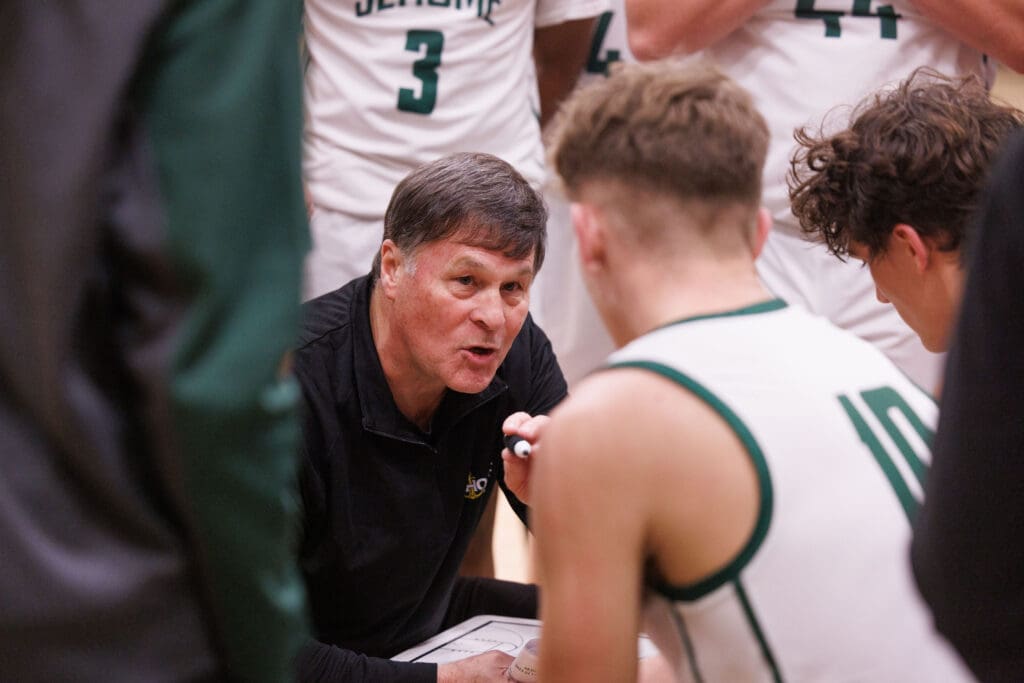 Sehome head coach Brad Jackson gives his team advice as he's surrounded in a close huddle.