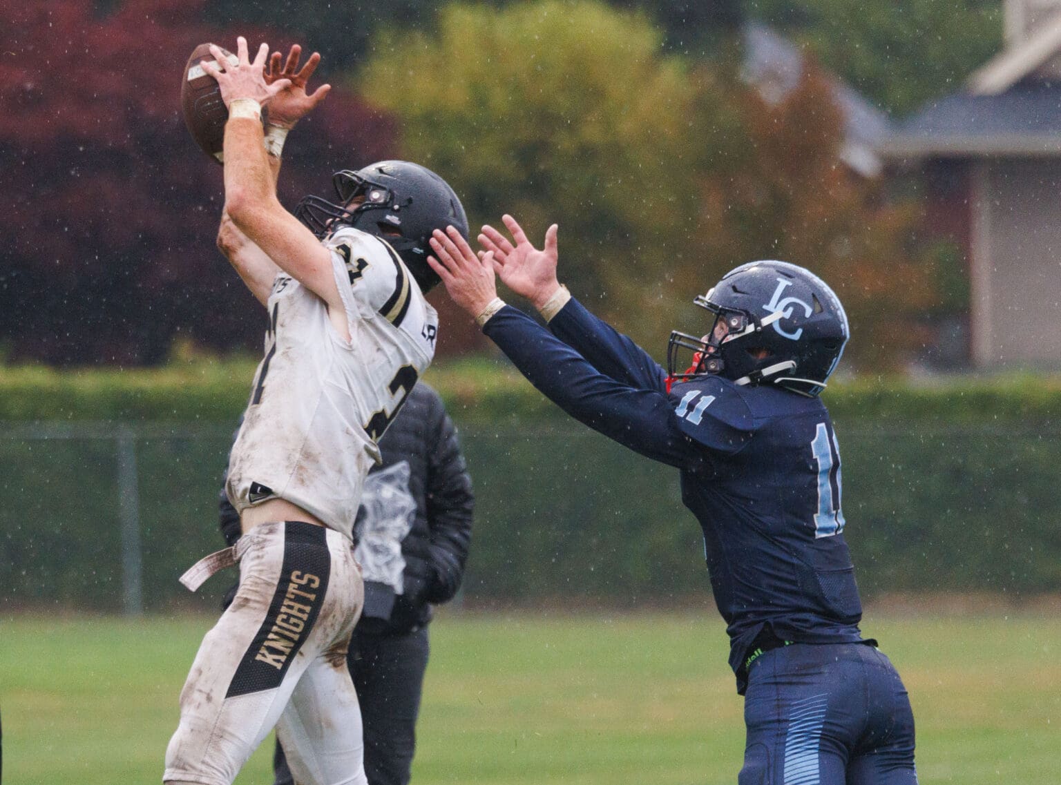 A Royal defender leaps with his arms stretched out to block an intended pass for Lynden Christian's Dawson Bouma.