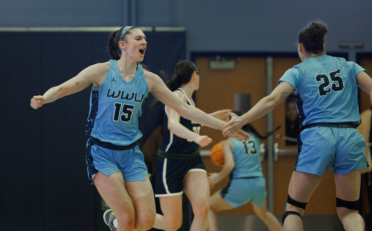 Western Washington University's Brooke Walling gets a low highfive from her teammate as other players slow down around them.