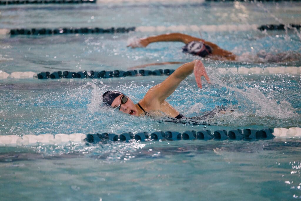 Mackenzie Millican sprints ahead of her teammate Mars Molina as she breaches sideways for a breath.