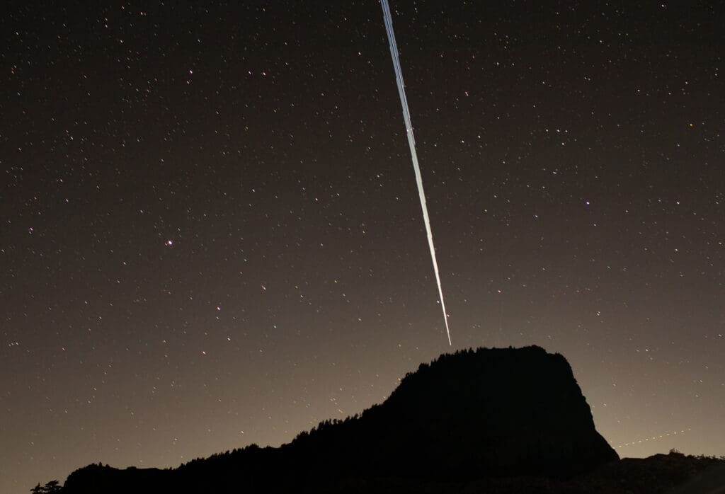 Starlink streaks through the starry night sky above Table Mountain.