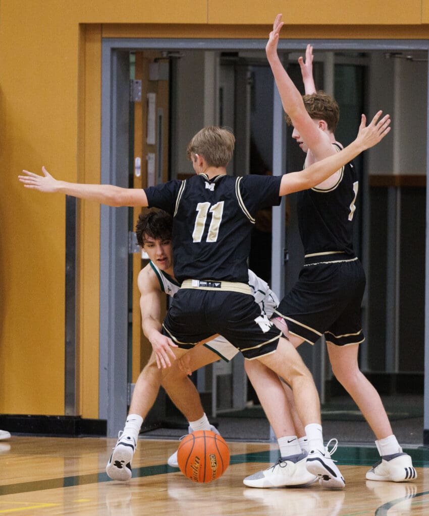 Sehome’s Nolan Wright makes a pass under pressure from Meridian’s Alex Short and Talon Jenkins.