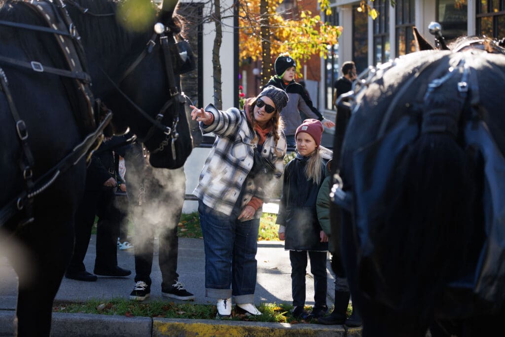Traci Bjorklund points to a black horse to her daughter, Mia.